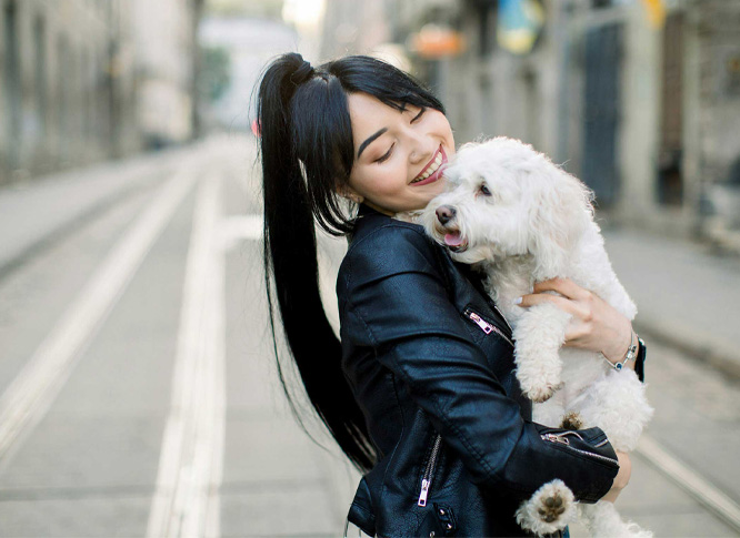 owner girl carrying a white dog